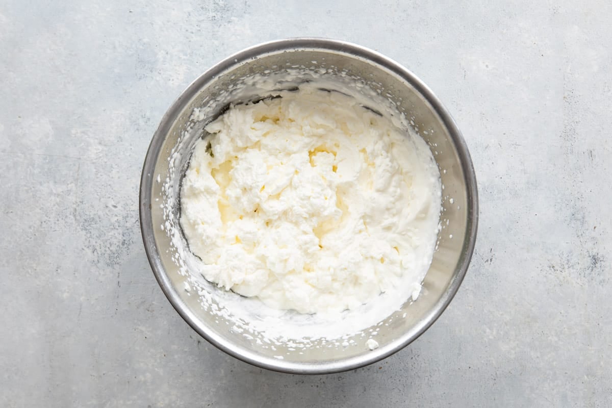 Cream cheese filling for no bake lemon cheesecake in a mixing bowl.