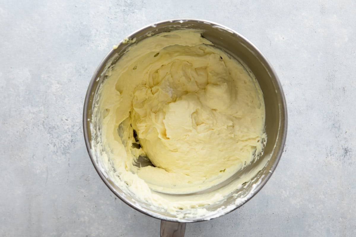 Filling for no bake lemon cheesecake in a silver mixing bowl.