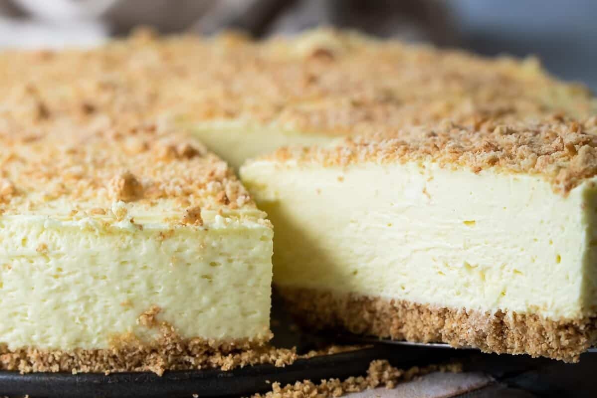 A no bake lemon cheesecake with a piece being removed.