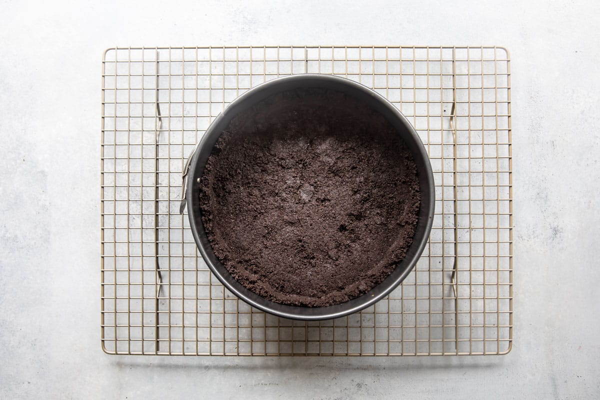 An oreo cookie crust on a wire rack.