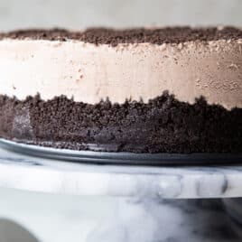 Frosty cheesecake on a marble serving platter.
