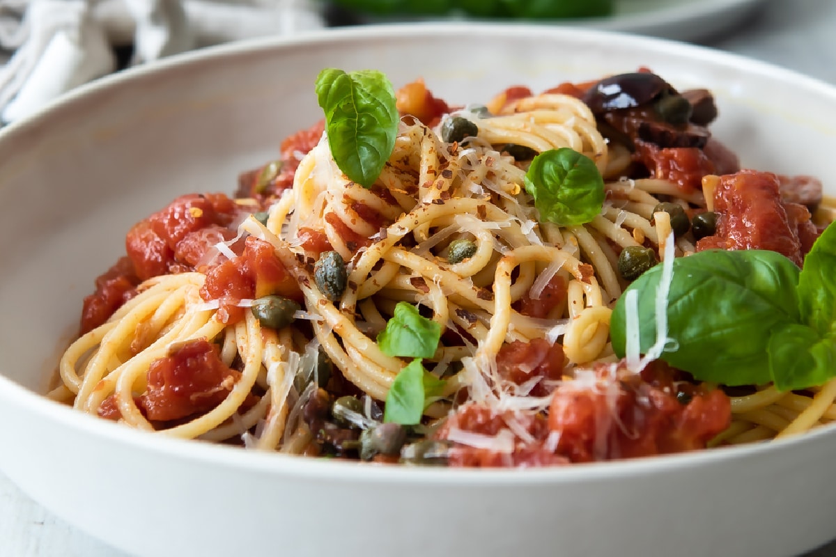Pasta Puttanesca in a white bowl.