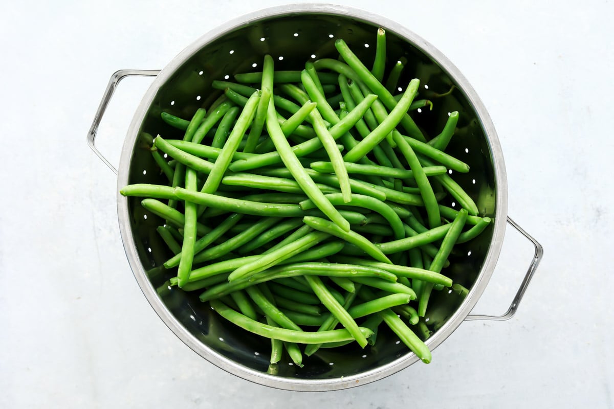 A colander full of fresh green beans.