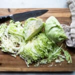 Cut cabbage on a wooden cutting board.