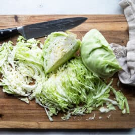 Cut cabbage on a wooden cutting board.