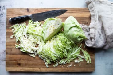 Cut cabbage on a wooden cutting board.