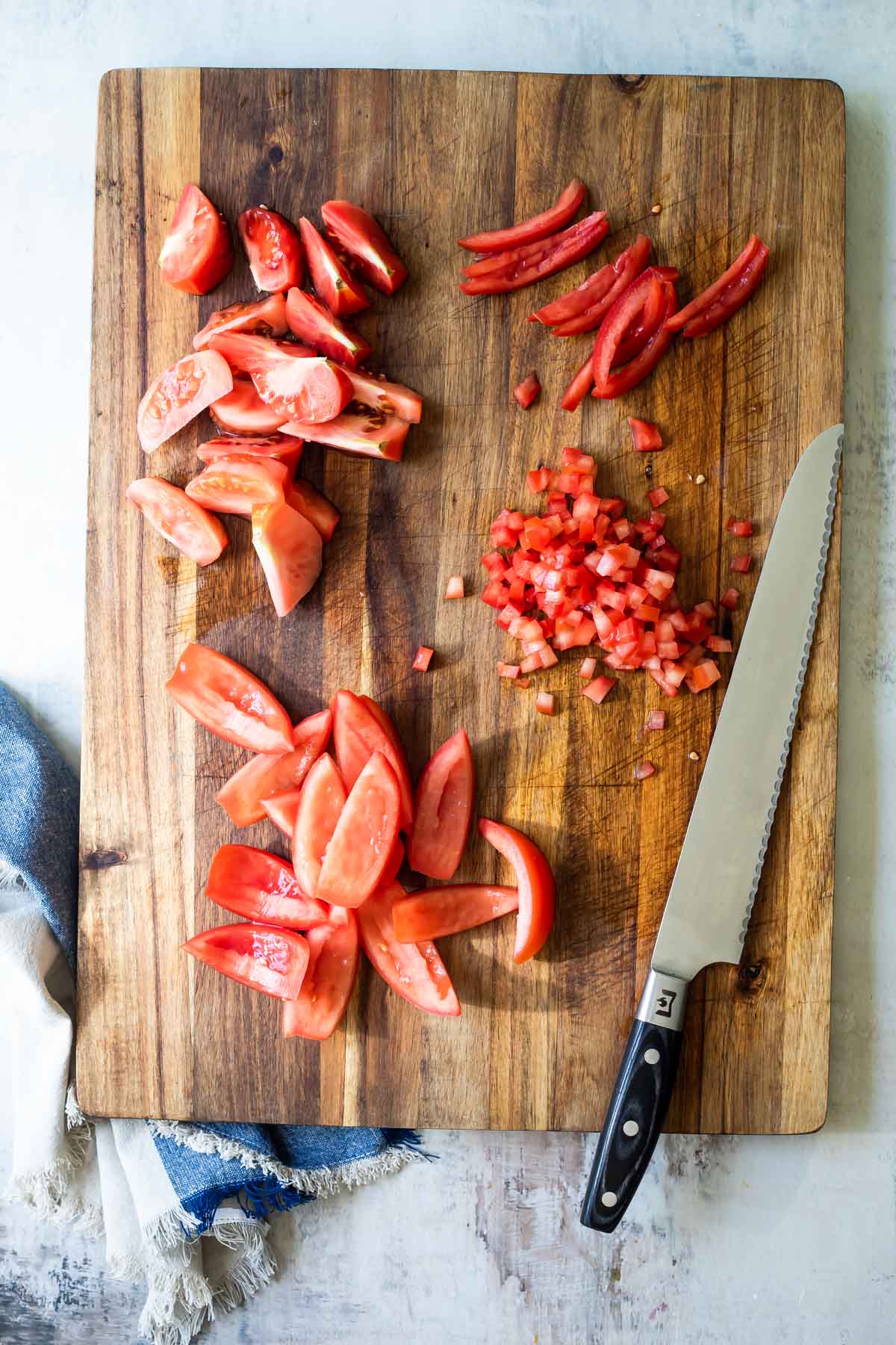 Seeding tomatoes on a cutting board.