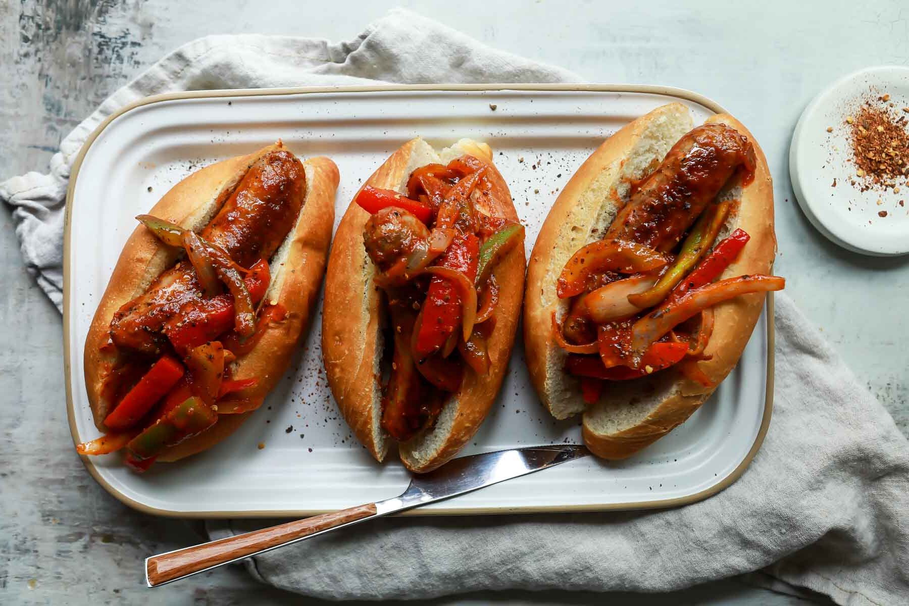 A platter of sausage and pepper sandwiches.