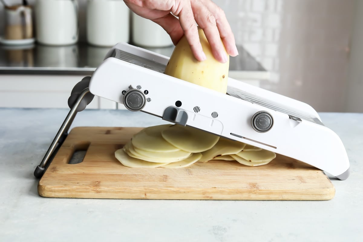 Slicing potatoes on a mandoline slicer.