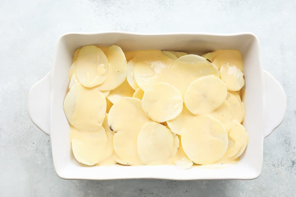 Sliced potatoes layered in a baking dish.