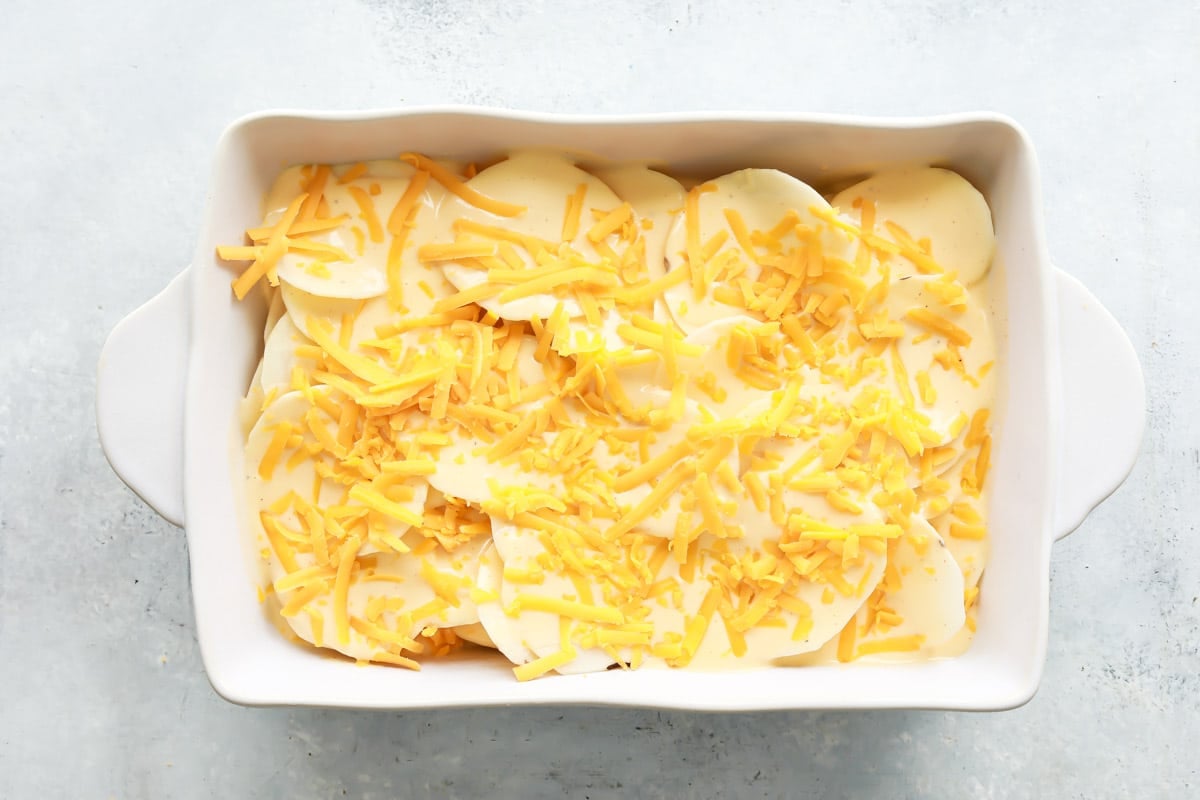 A 9x13 baking pan full of unbaked scalloped potatoes.