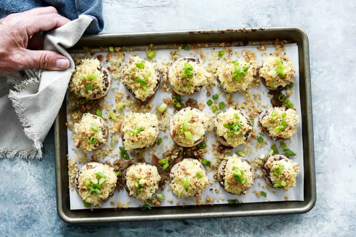 A baking sheet full of stuffed mushrooms.