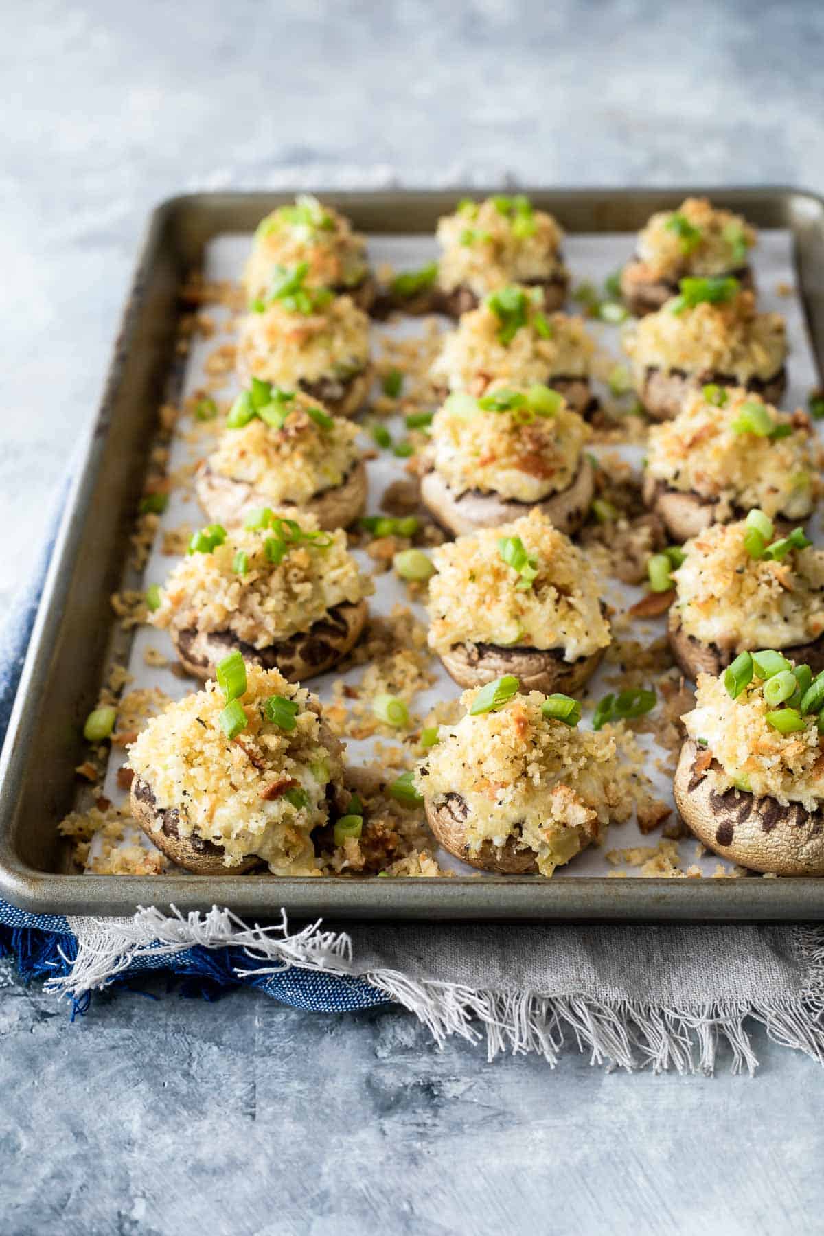A baking sheet full of stuffed mushrooms.