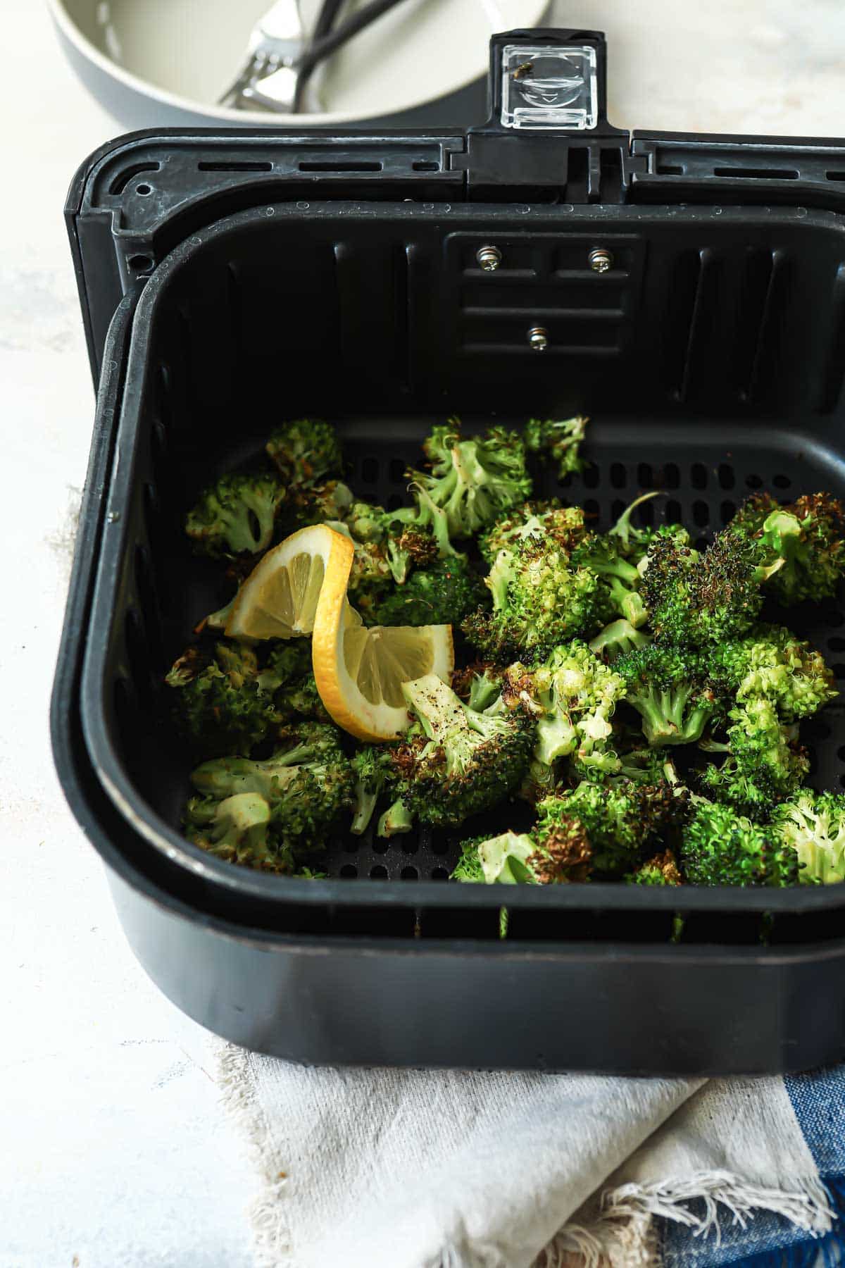 Air fryer broccoli in an air fryer basket.