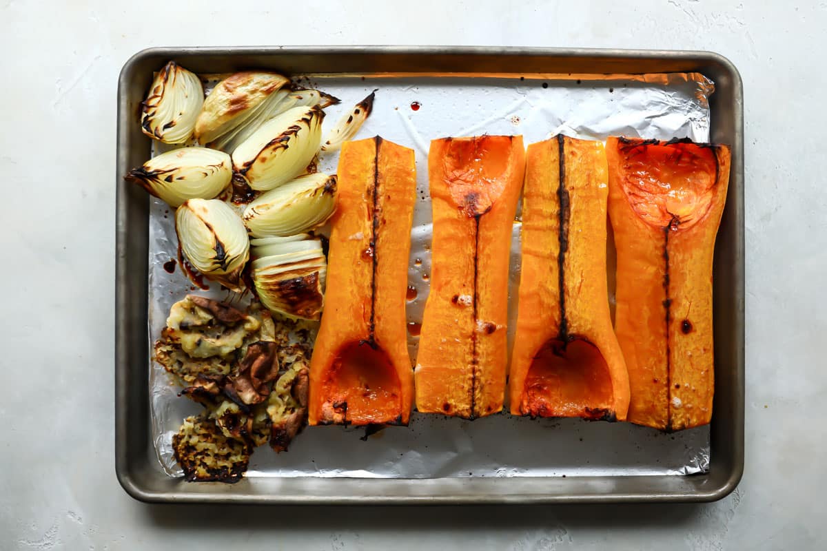 baking sheet with roasted butternut squash quarters and roasted onions and apples. 
