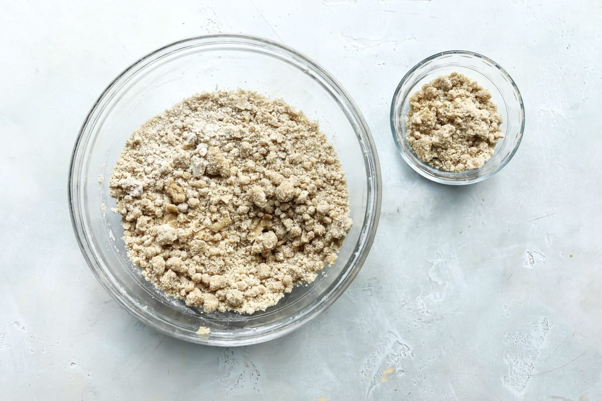 Divided coffee cake crumble in two clear bowls.