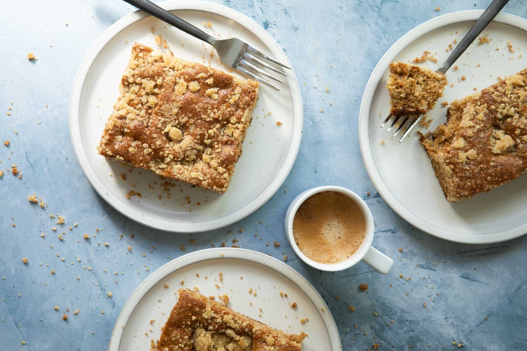 Three plates with coffee cake slices on them.