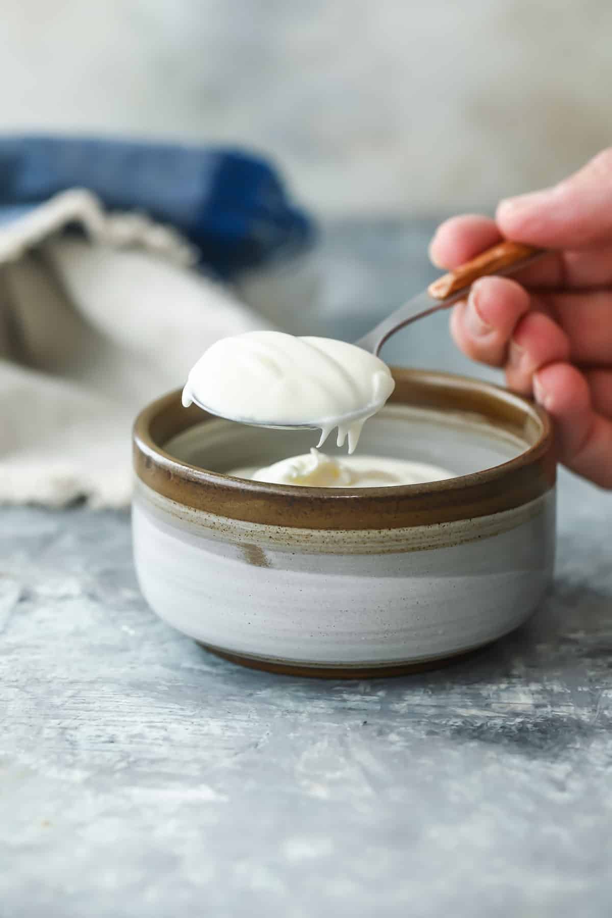 Creme Fraiche being spooned out of a small bowl.