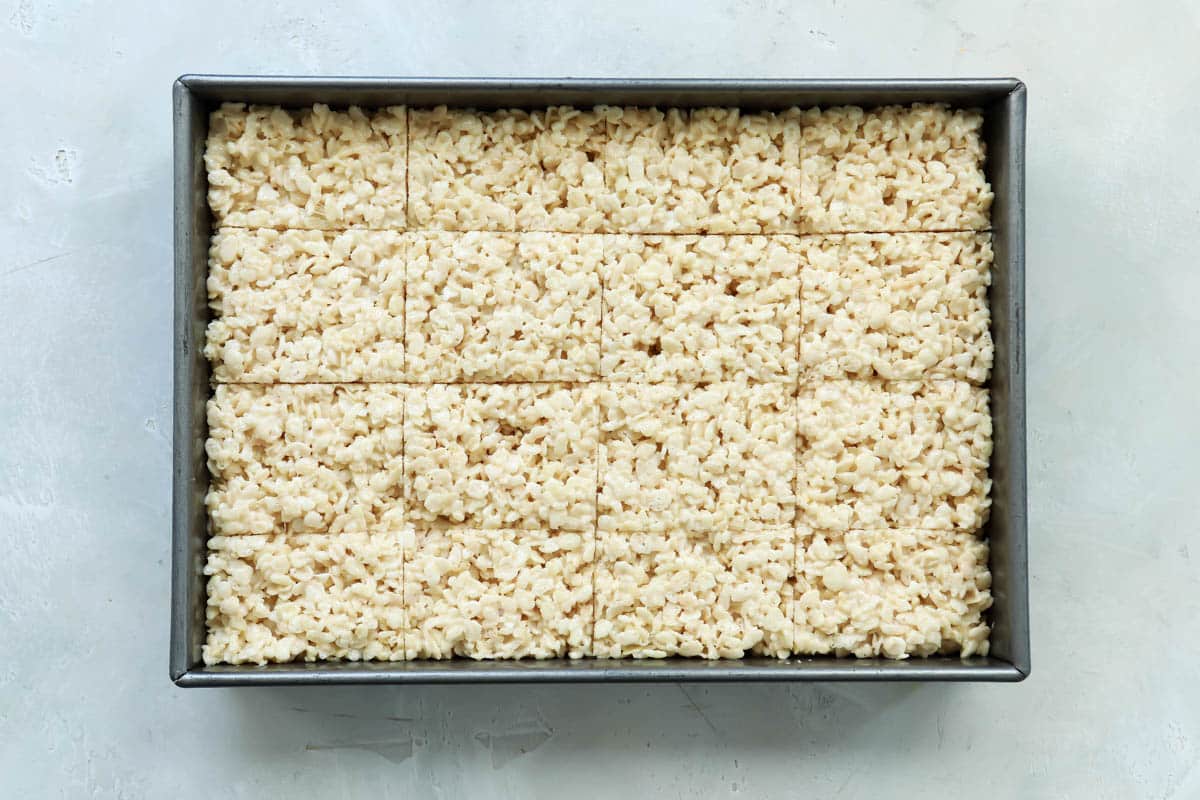 Plain rice krispie treats in a pan cut into rectangles.