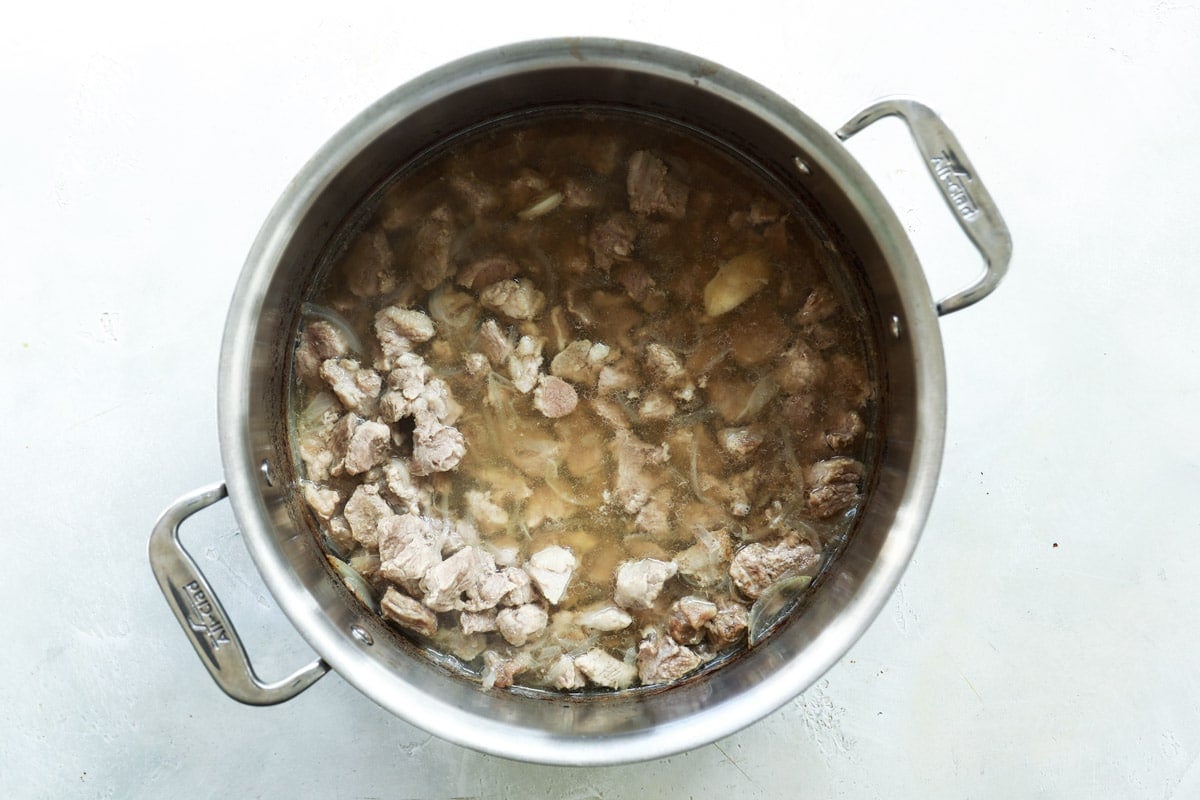 A pork shoulder being boiled to make pork broth.