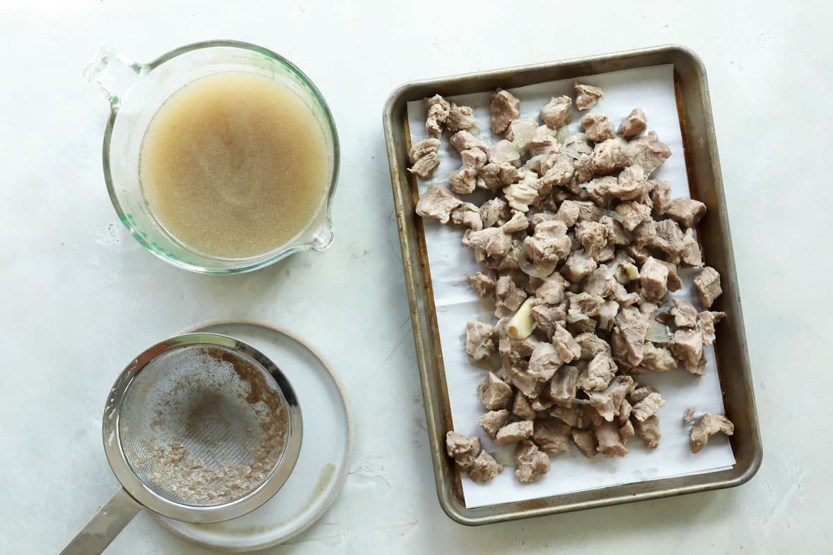 Pork being separated from a pork shoulder to make pork broth.