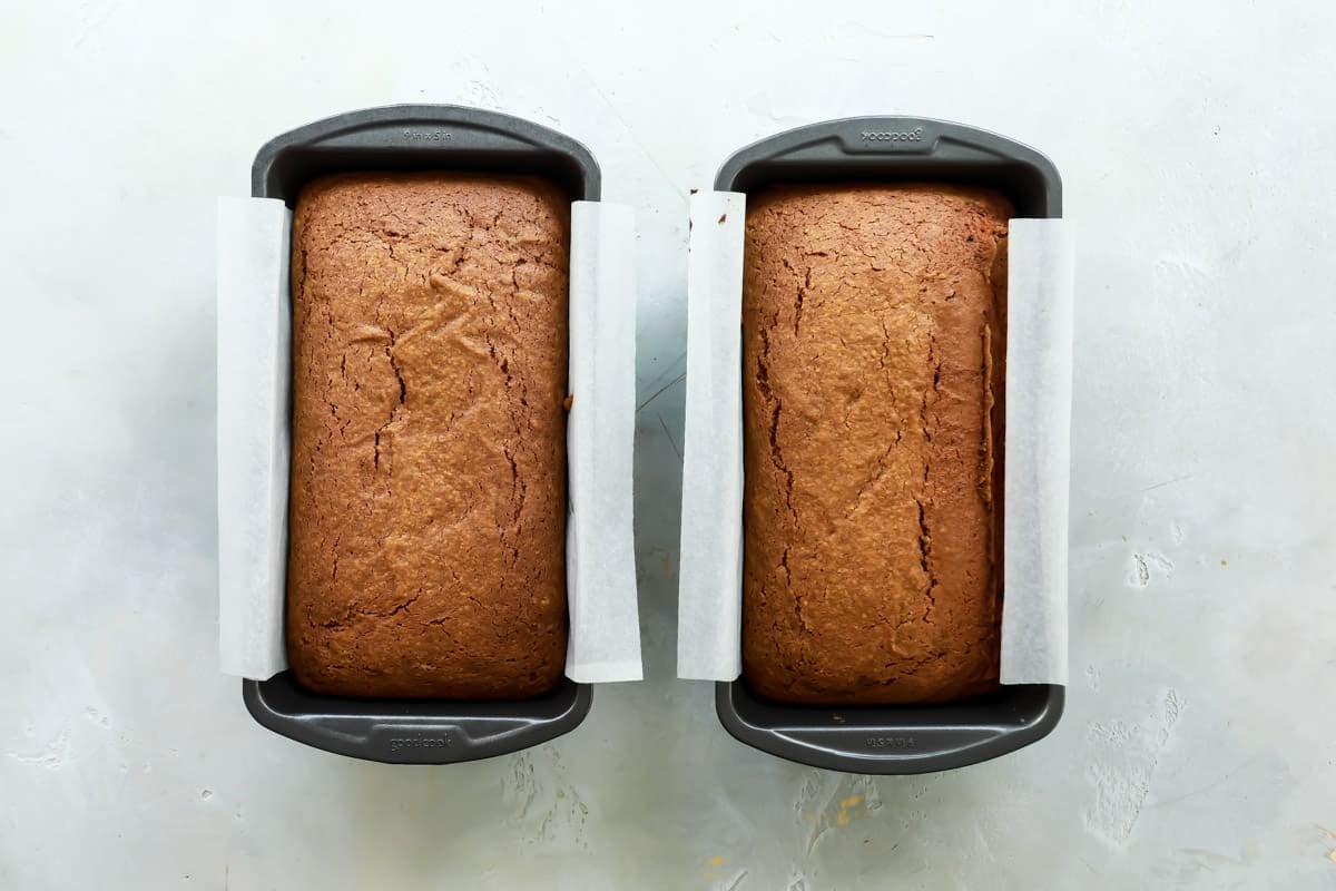 Two loaves of pumpkin bread in pants after being baked.