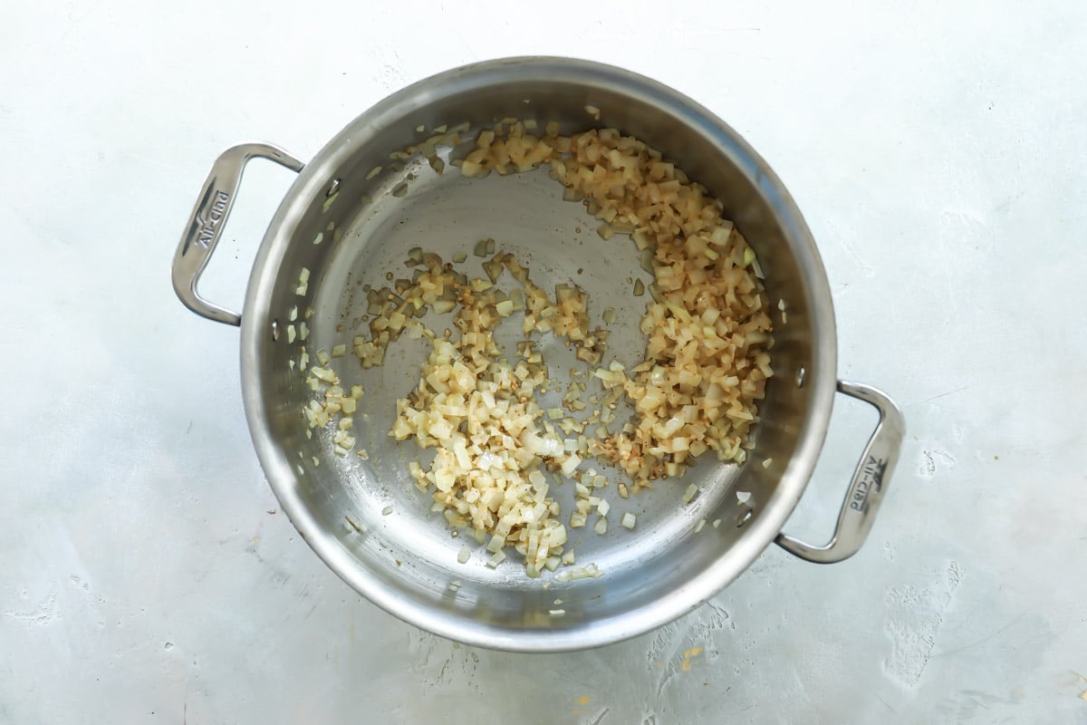 Onion and garlic in a silver pot.