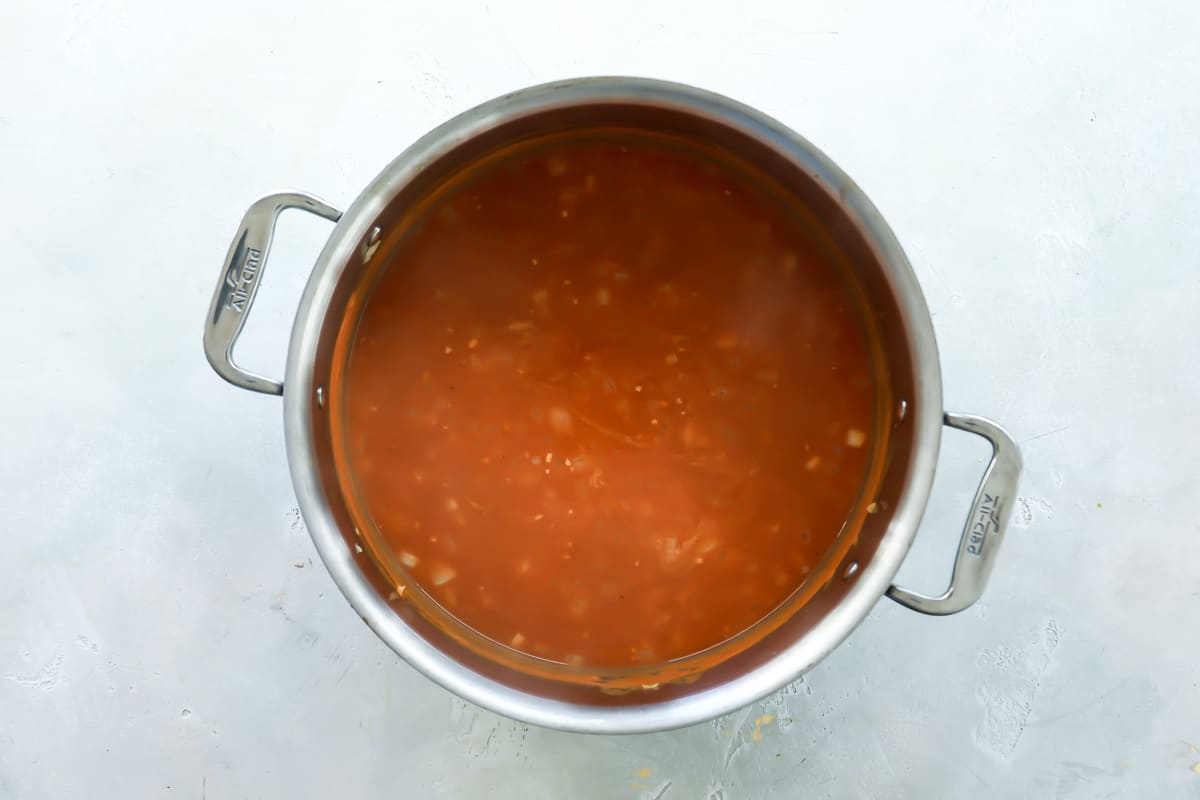 A pot filled with ingredients for pumpkin soup.
