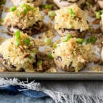 A baking sheet full of stuffed mushrooms.