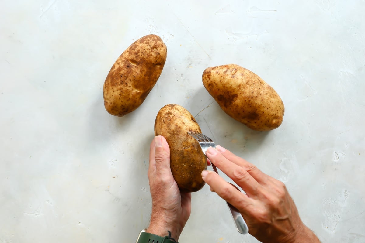 Poking holes in potatoes with a fork.