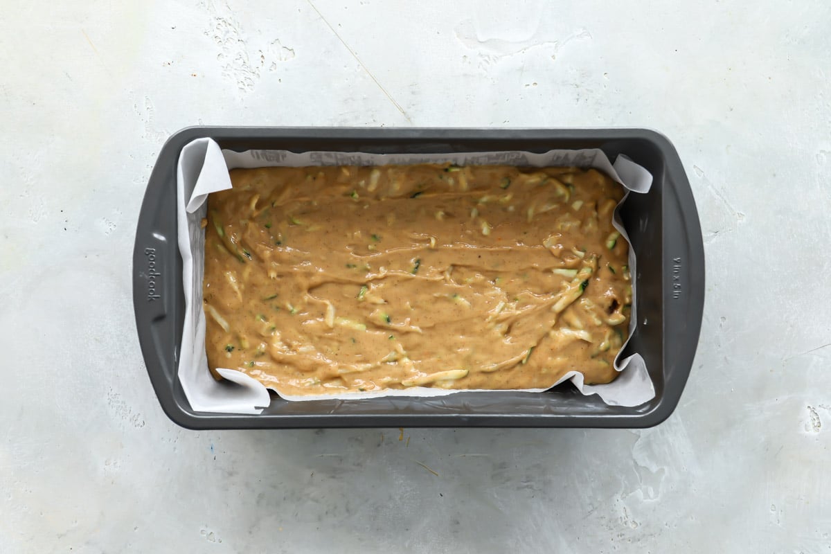 Zucchini bread batter in a gray loaf pan.