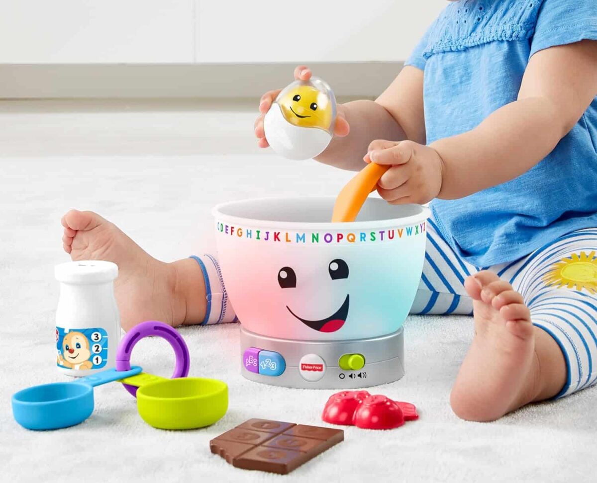 A child playing with a laugh and learn mixing bowl.