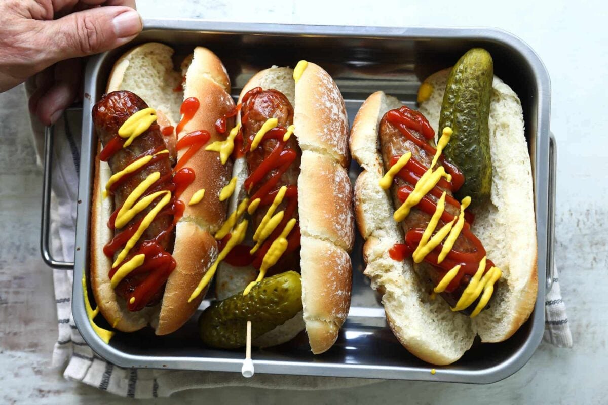 A metal pan with three air fryer bratwurst.