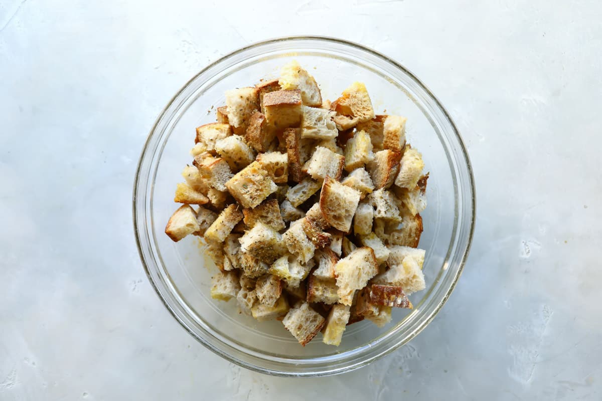 A glass bowl with bread cubes in it.