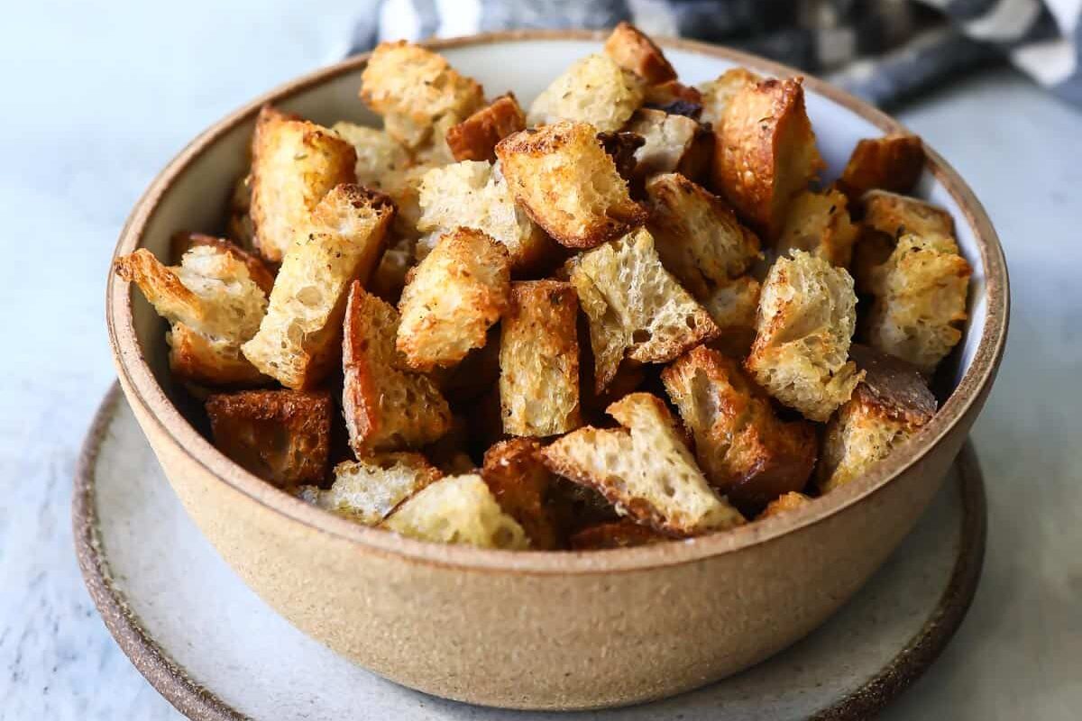 Air fryer croutons in a brown bowl.
