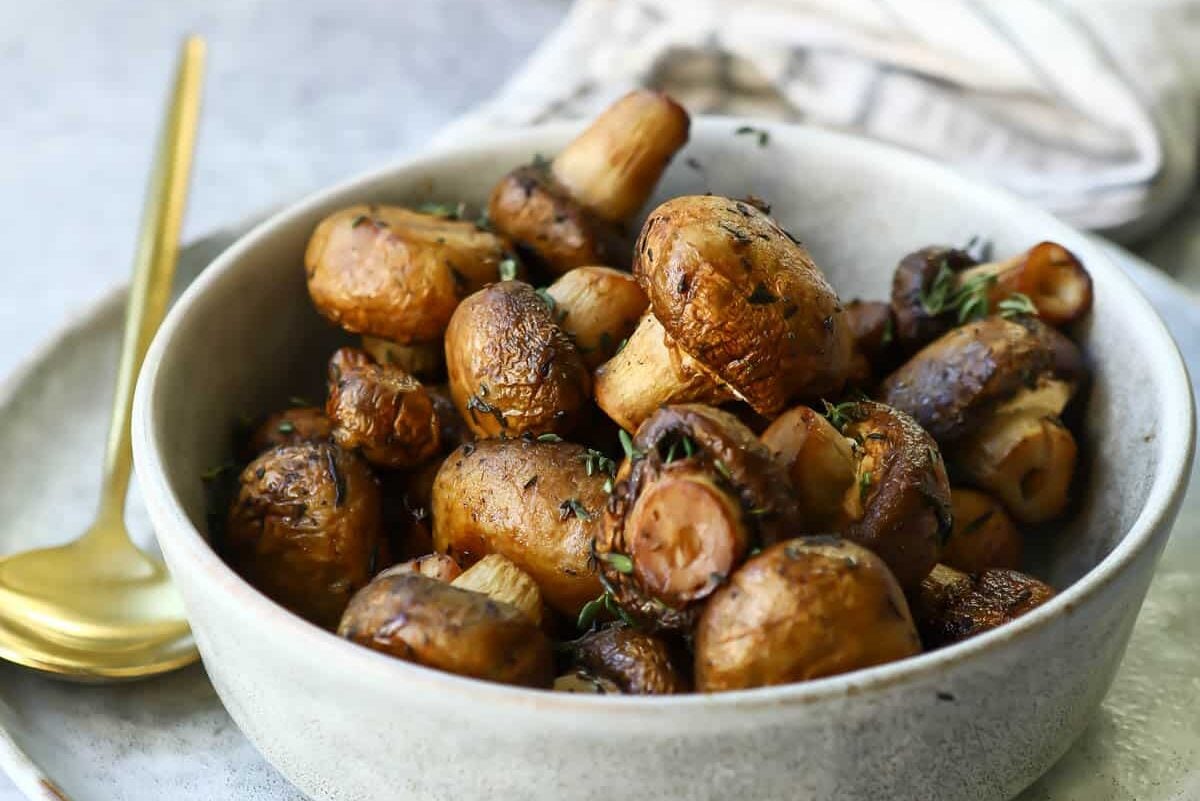 A small gray bowl with whole air fried mushrooms.