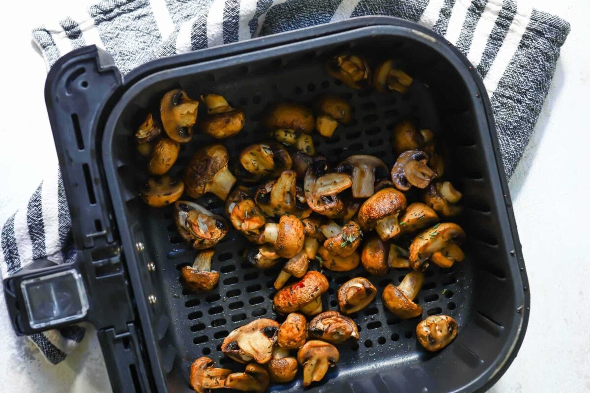Mushrooms in an air fryer basket.