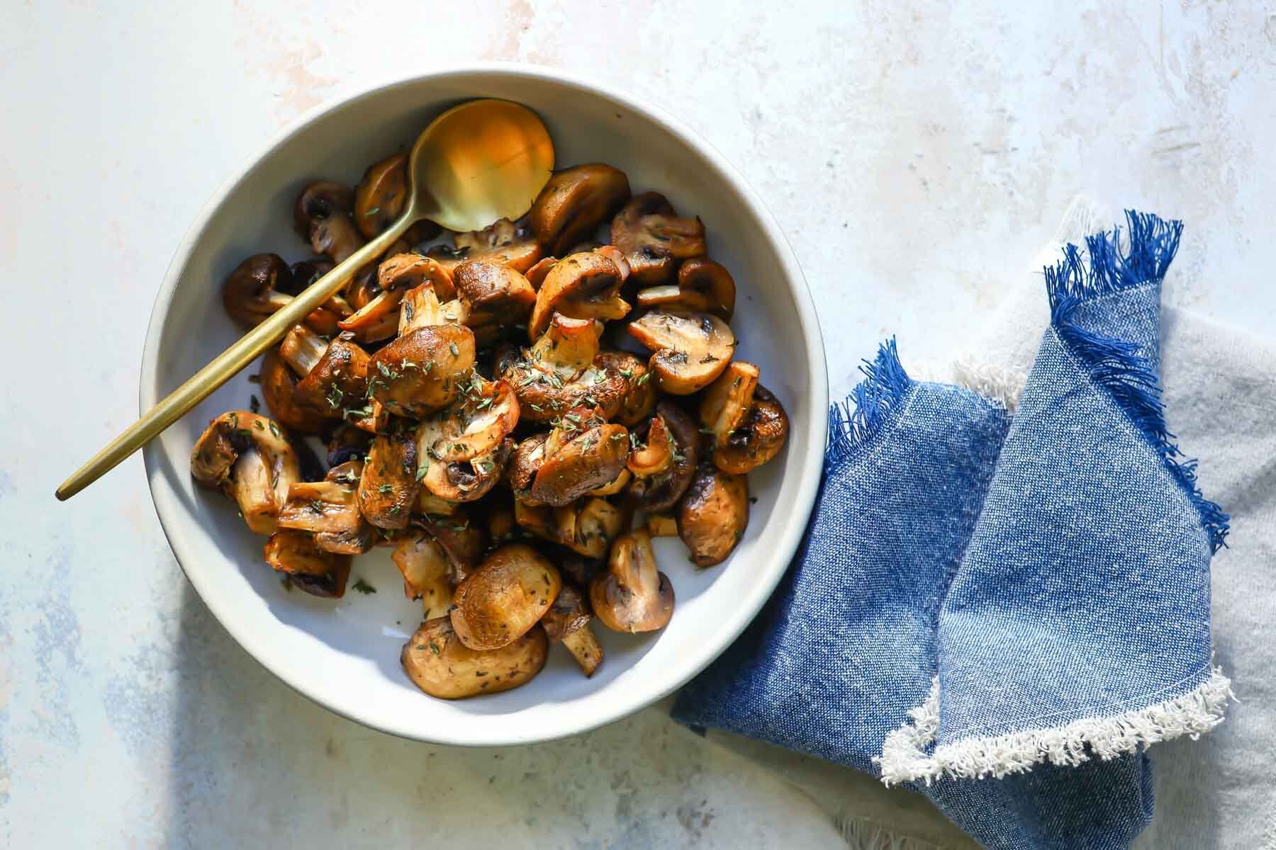 Air fryer mushrooms in a white bowl.