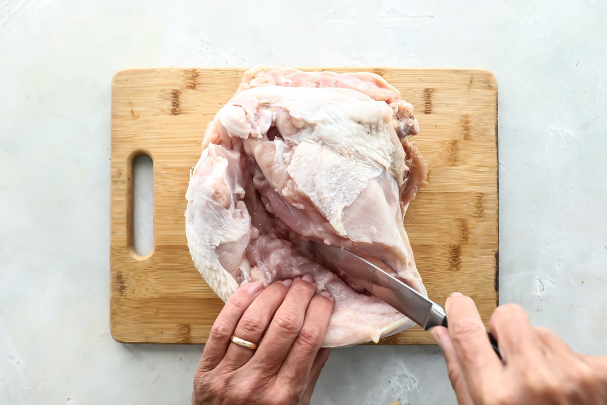 Someone preparing a turkey breast before air frying it.