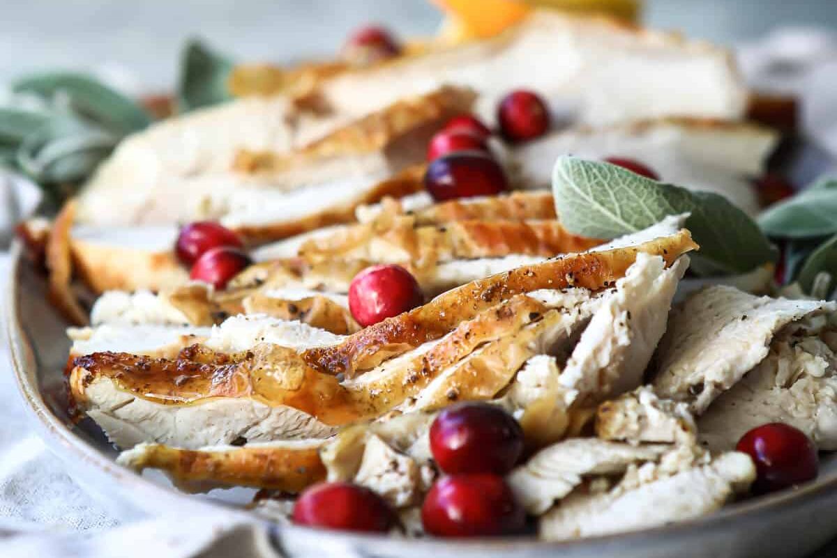 Slices of air fryer turkey on an oval platter.