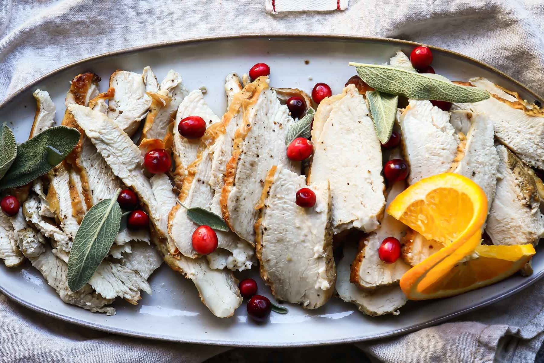 Slices of air fryer turkey on an oval platter.