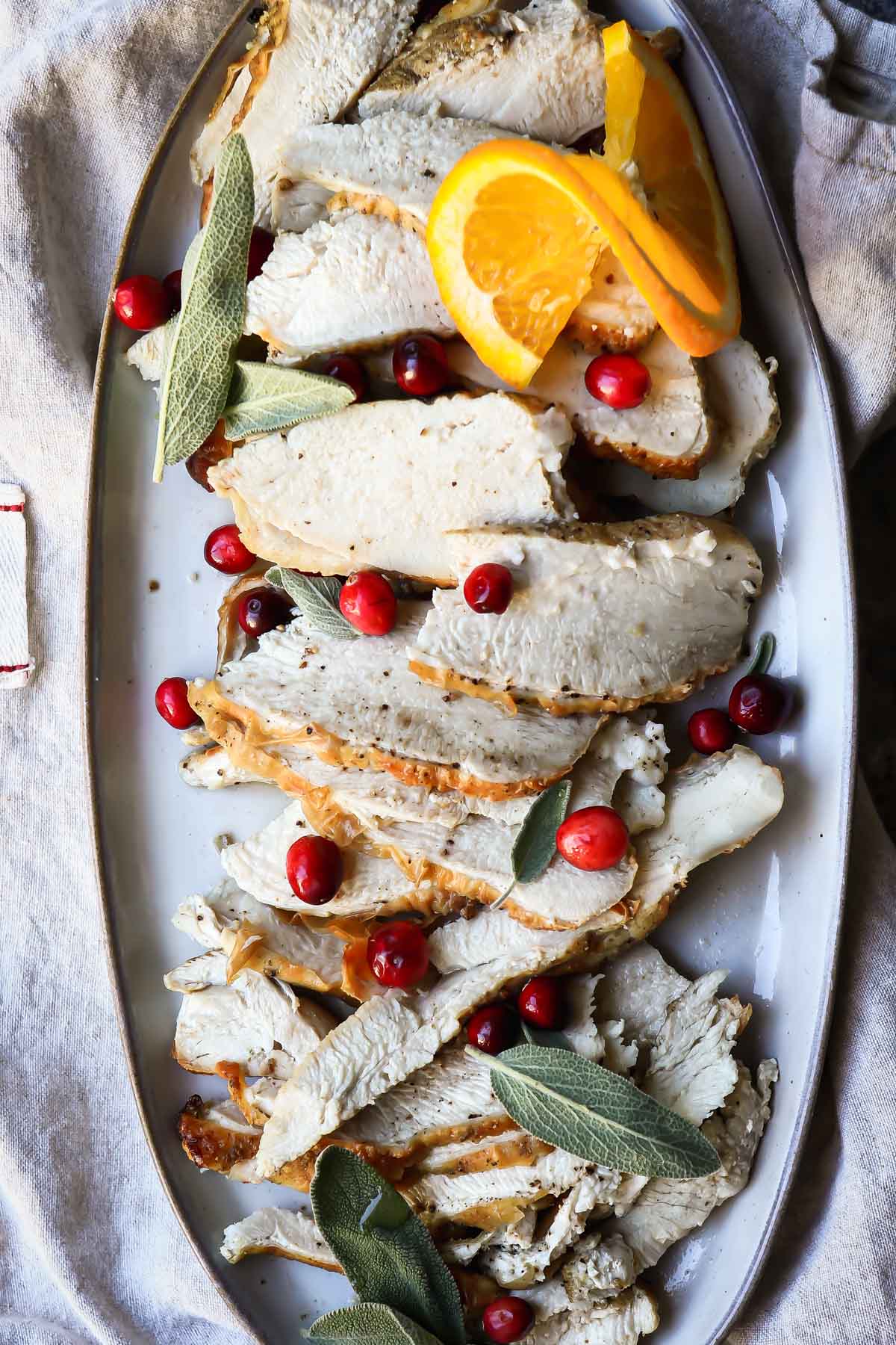 Slices of air fryer turkey on an oval platter.
