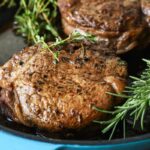 Two filets in a teal skillet.