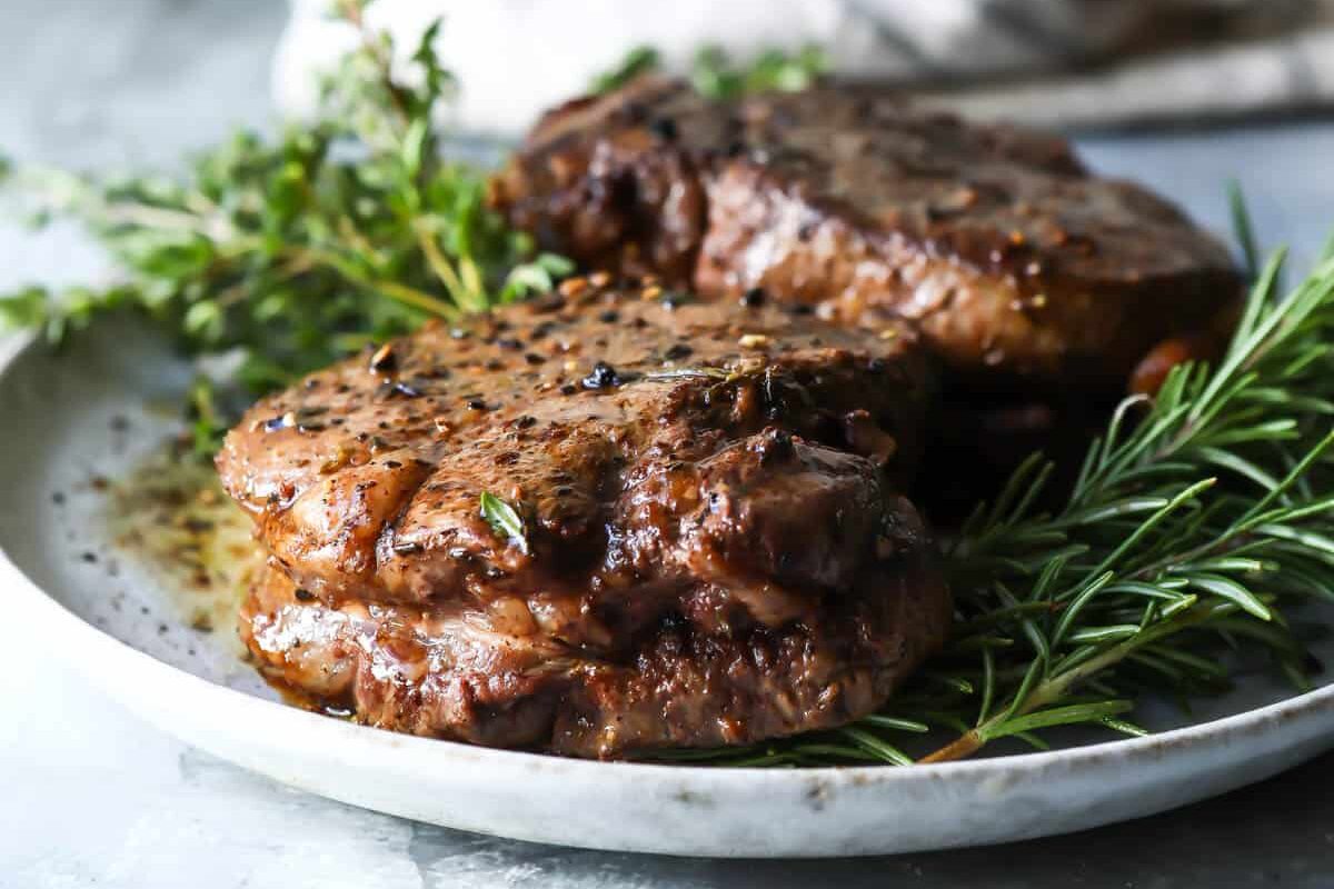 Two filet mignons on a gray plate.
