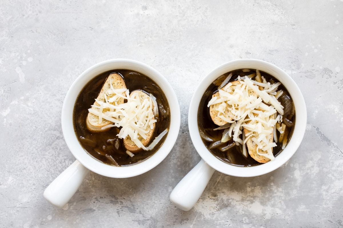 French onion soup in white bowls.