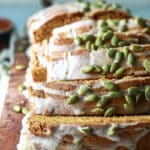 A loaf of pumpkin bread sliced on a wooden cutting board.