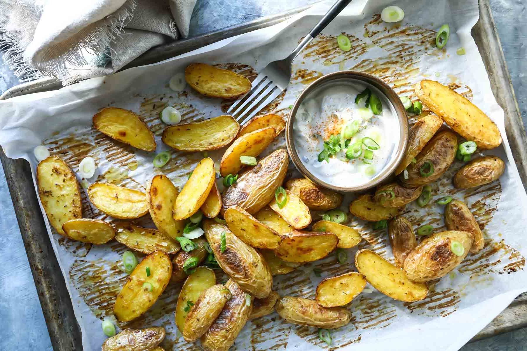 Roasted fingerling potatoes on a baking sheet.