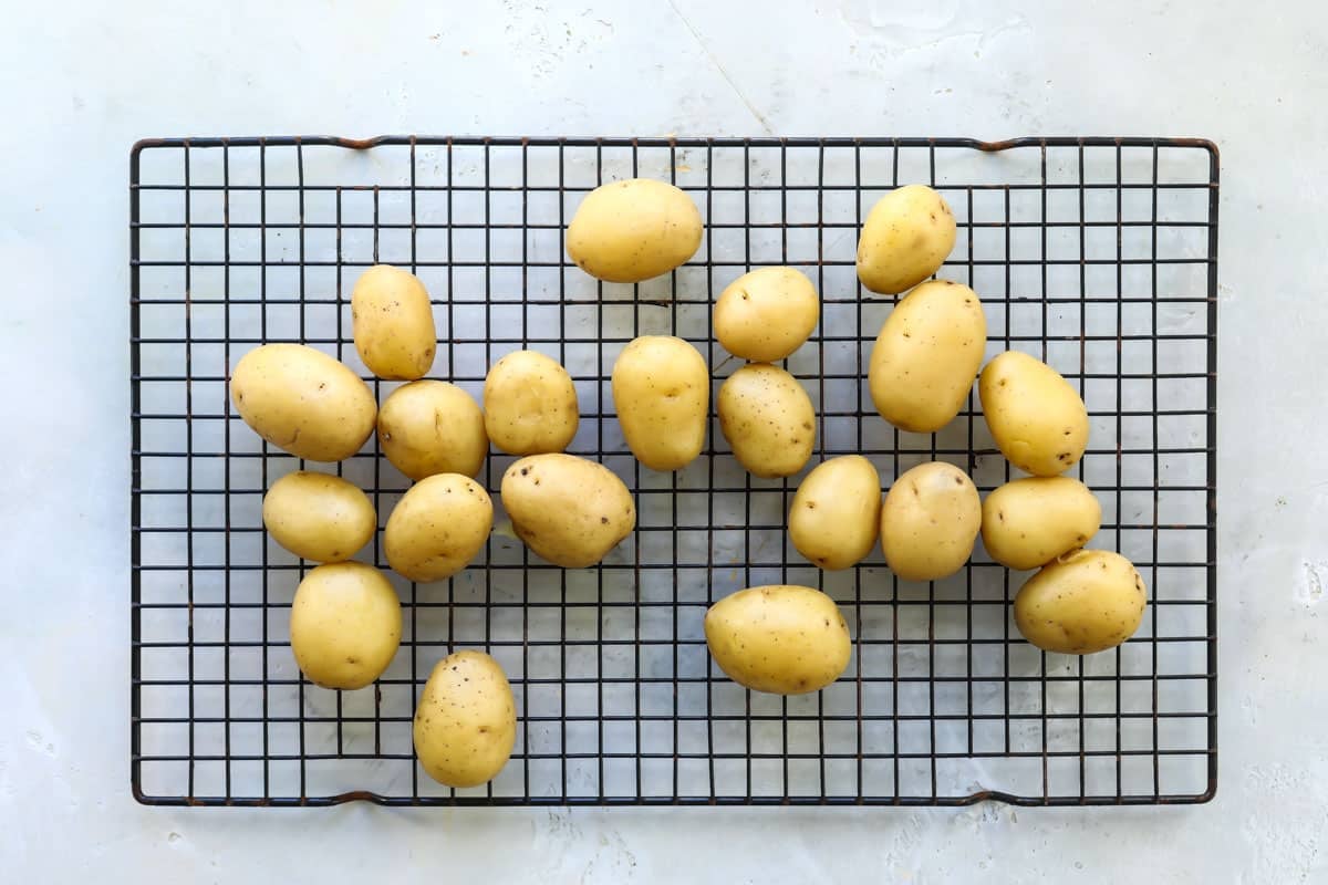 Washed baby Yukon gold potatoes on a wire rack.