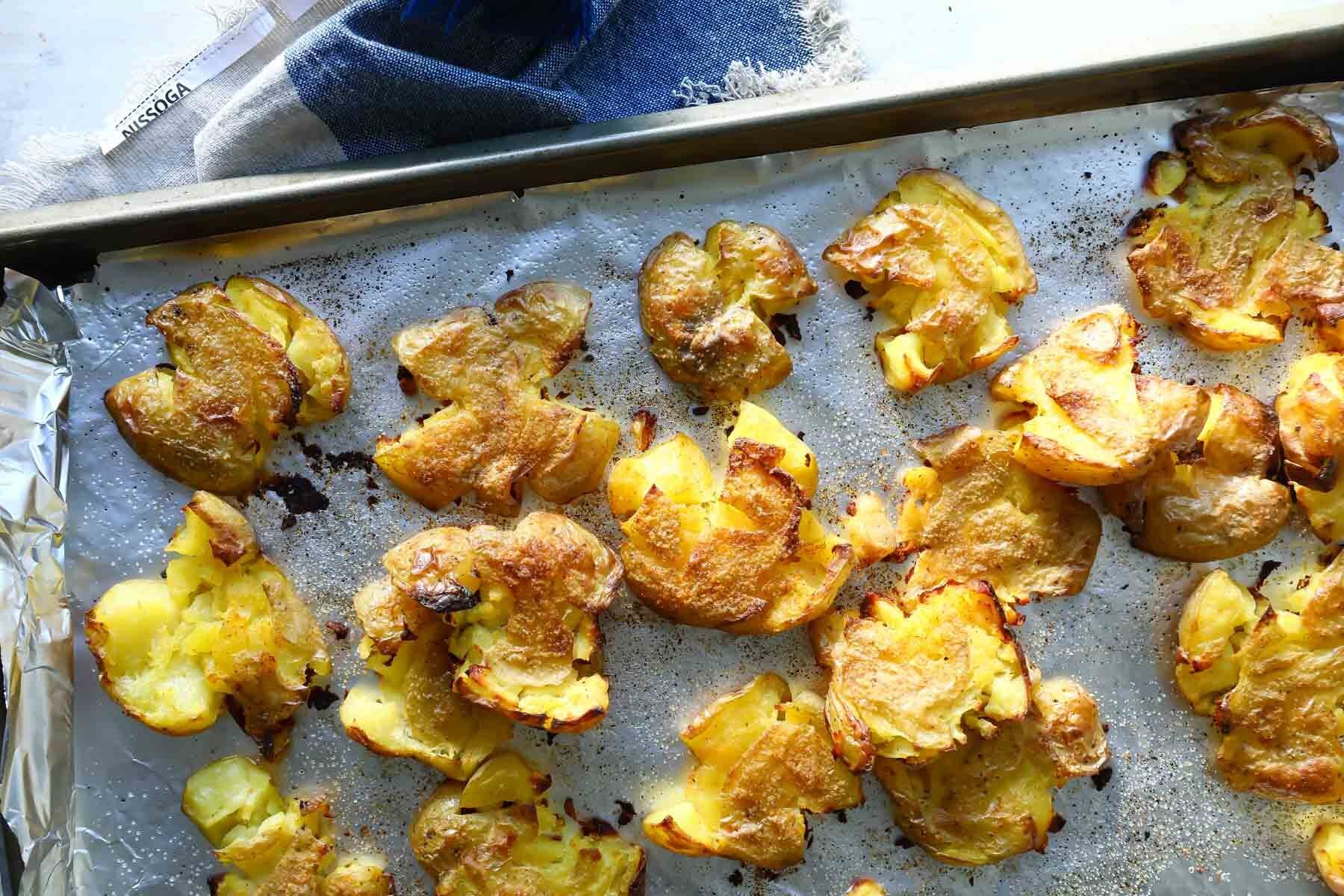 Smashed potatoes on a baking sheet.
