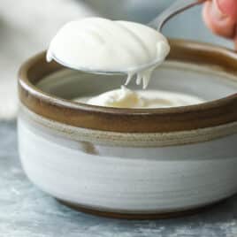 Creme Fraiche being spooned out of a small bowl.